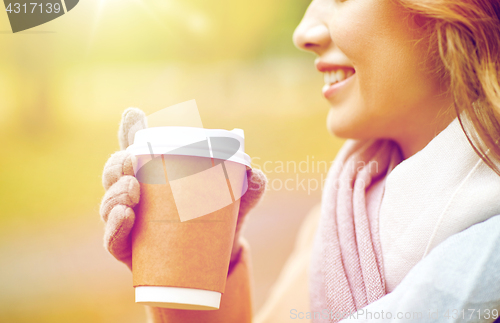 Image of close up of happy woman with coffee in autumn park