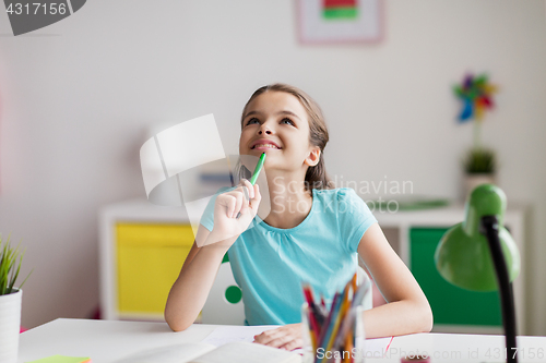 Image of happy girl with book and notebook dreaming at home