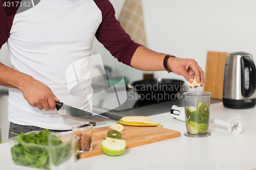 Image of man with blender and fruit cooking at home kitchen