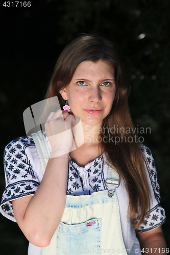 Image of Young woman with summer sprouts and dungarees while fishing