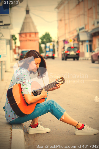 Image of beautiful european woman with guitar