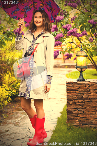 Image of woman dressed up in a raincoat with an umbrella