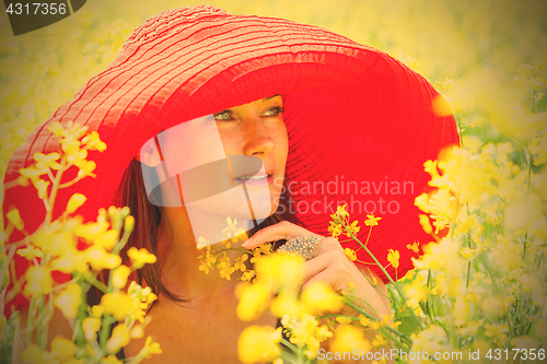 Image of woman in a red hat on a sunny day amidst wildflowers. portrait, 