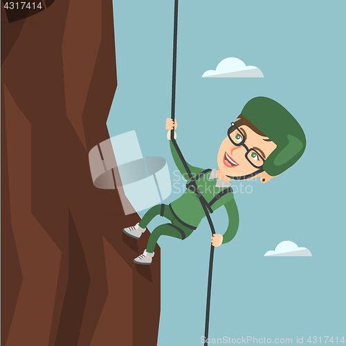 Image of Caucasian woman climbing a mountain with rope.