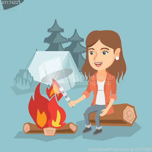 Image of Caucasian girl roasting marshmallow over campfire.