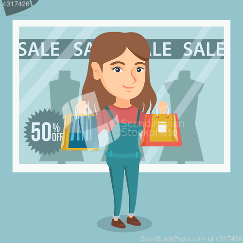Image of Young caucasian woman shopping on sale.