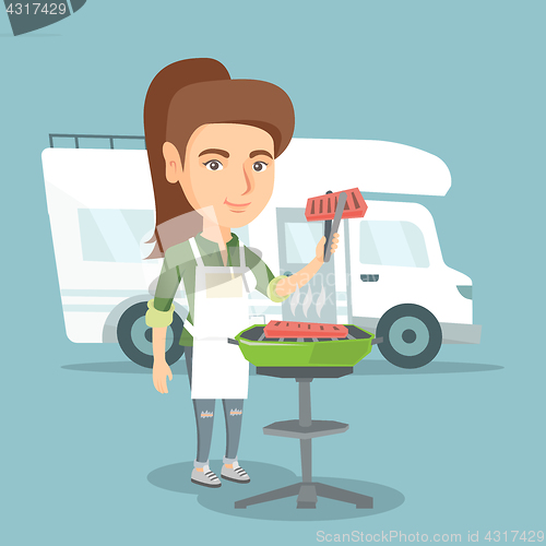 Image of Woman barbecuing meat in front of camper van.