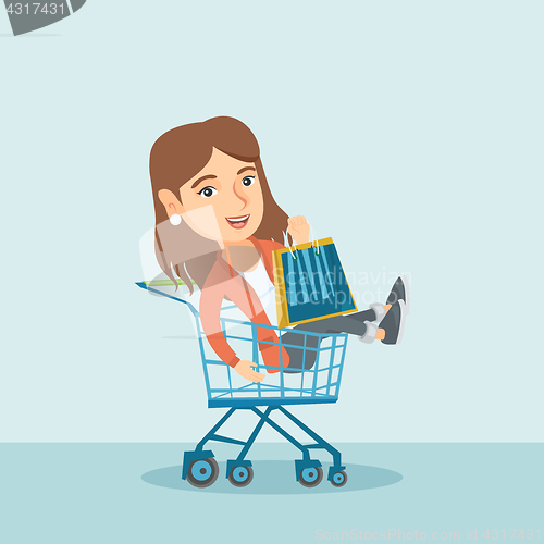 Image of Young caucasian woman riding in shopping trolley.