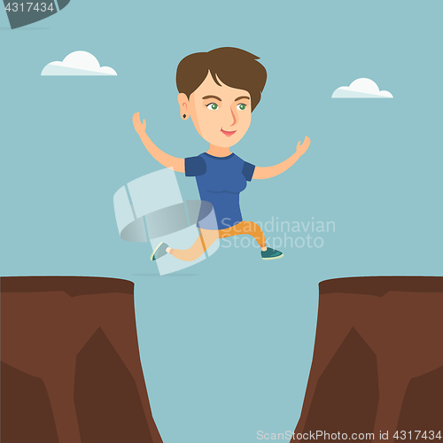 Image of Young caucasian sportswoman jumping over the cliff