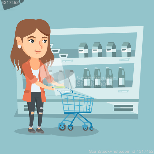 Image of Young caucasian woman with a supermarket trolley.