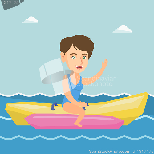 Image of Young happy caucasian woman riding a banana boat.