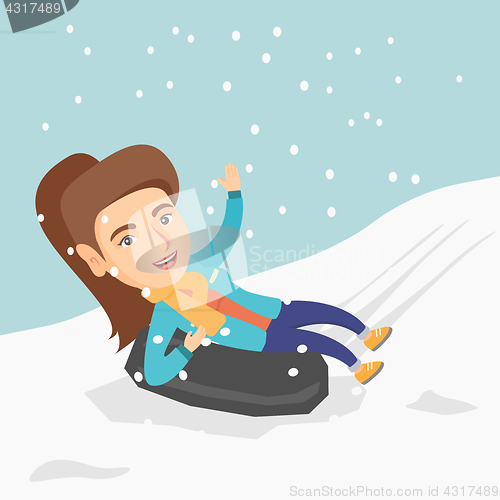 Image of Girl sledding on snow rubber tube in the mountains