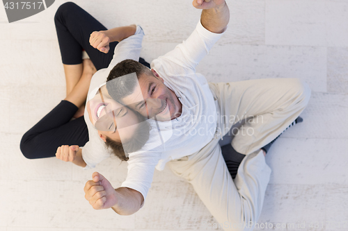 Image of couple sitting with back to each other on floor