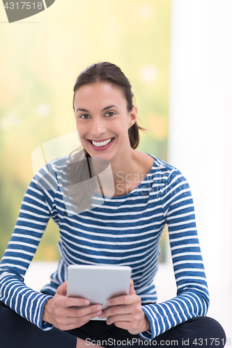 Image of young women using tablet computer on the floor