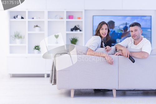 Image of Young couple on the sofa watching television