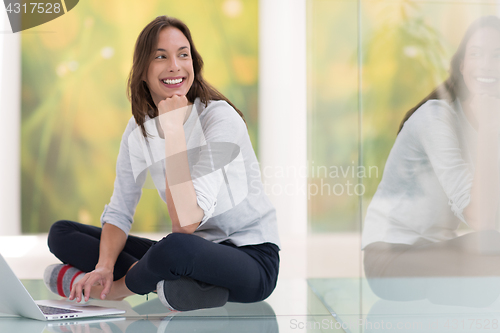 Image of young women using laptop computer on the floor