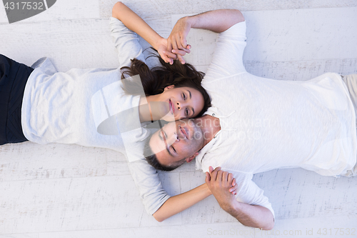 Image of handsome couple lying on floor