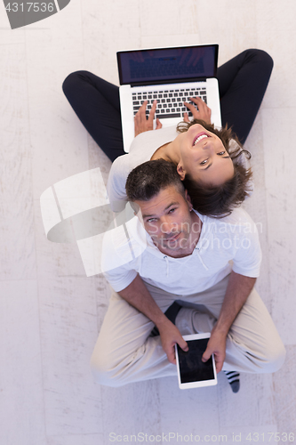 Image of couple using tablet and laptop computers top view