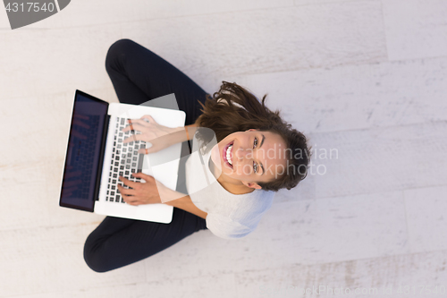 Image of women using laptop computer on the floor top view