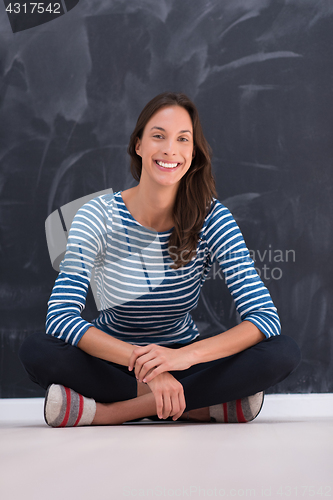Image of woman sitting in front of chalk drawing board