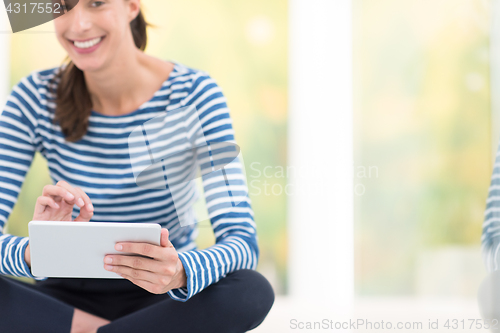 Image of young women using tablet computer on the floor