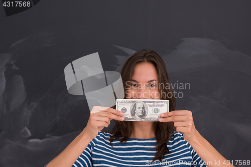 Image of woman holding a banknote in front of chalk drawing board