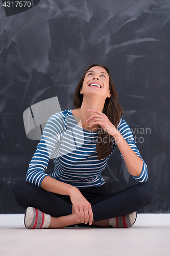Image of woman sitting in front of chalk drawing board