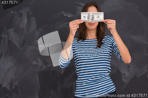 Image of woman holding a banknote in front of chalk drawing board