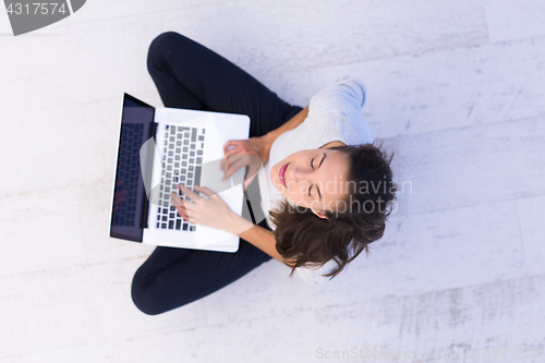 Image of women using laptop computer on the floor top view