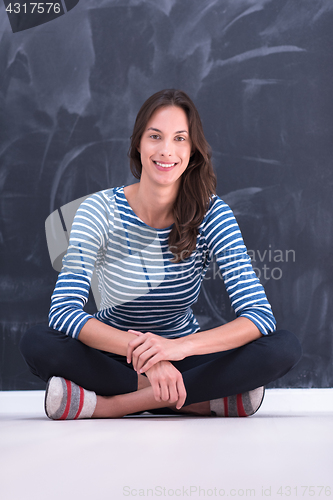 Image of woman sitting in front of chalk drawing board