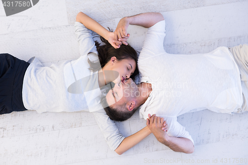 Image of handsome couple lying on floor