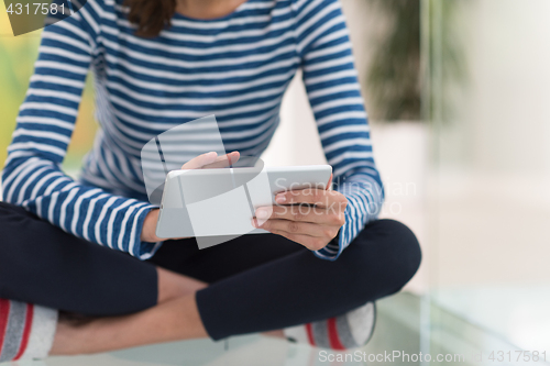 Image of young women using tablet computer on the floor