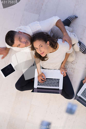 Image of couple using tablet and laptop computers top view