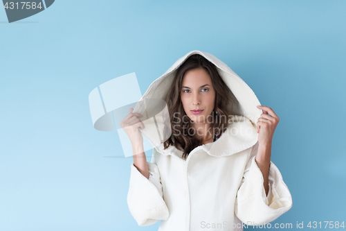 Image of woman in a white coat with hood isolated on blue background