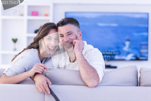 Image of Young couple on the sofa watching television