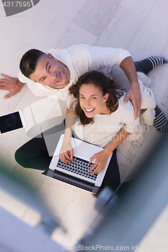 Image of couple using tablet and laptop computers top view