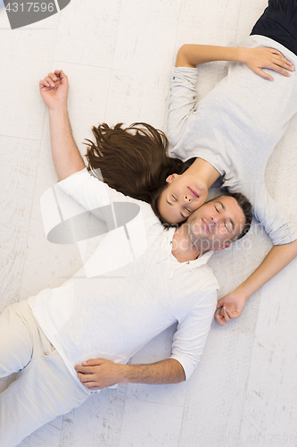 Image of handsome couple lying on floor