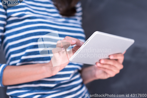 Image of woman using tablet  in front of chalk drawing board