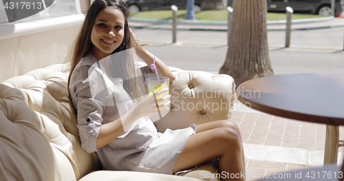 Image of Charming girl having refreshing drink in cafe