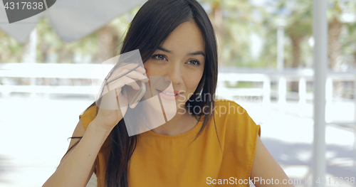 Image of Elegant woman talking phone outside