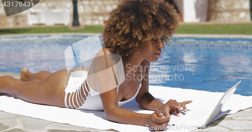 Image of Charming girl using laptop in pool