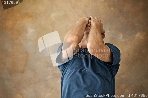 Image of Worried mature man touching his head.