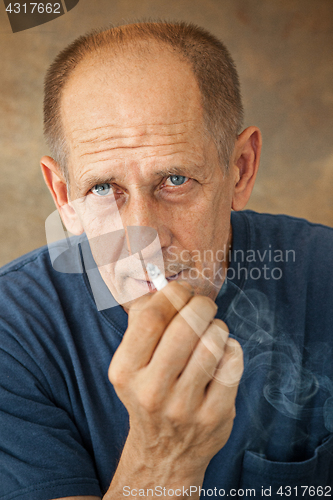 Image of Worried mature man sitting at studio