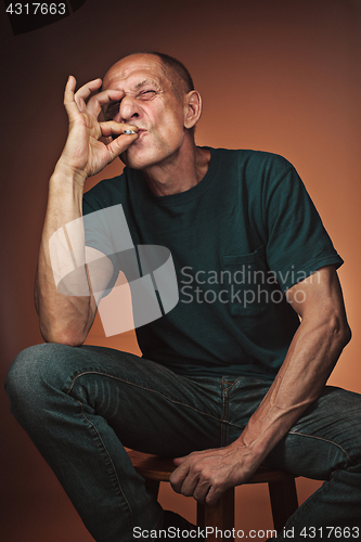 Image of Worried mature man sitting at studio