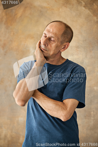 Image of Worried mature man touching his head.