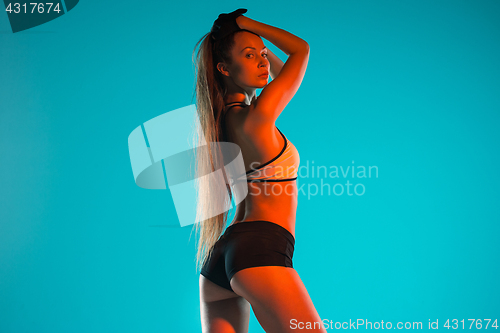 Image of Muscular young woman athlete posing at studio