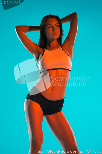 Image of Muscular young woman athlete posing at studio