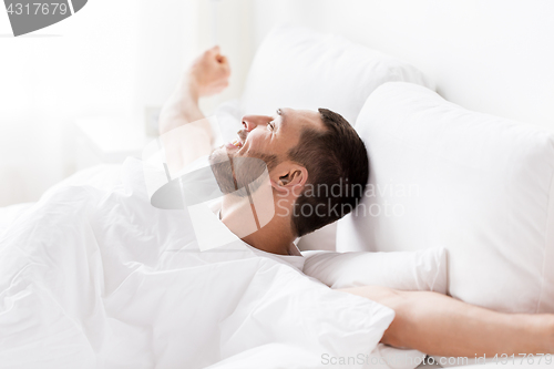Image of man lying in bed at home