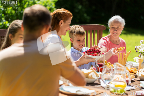 Image of happy family having dinner or summer garden party