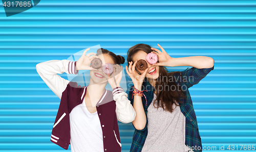 Image of happy pretty teenage girls with donuts having fun